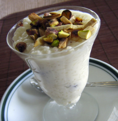 Indian kheer (rice pudding) with slivered almonds and pistashios in a glass tulip sundae dessert dish