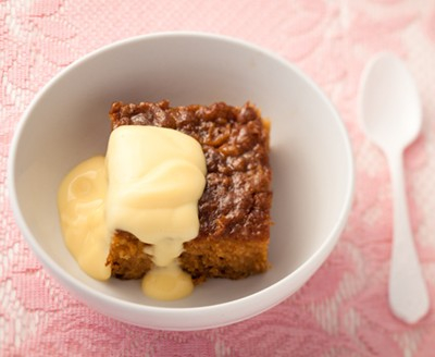 South African Malva Pudding in a white bowl on a pink table cloth