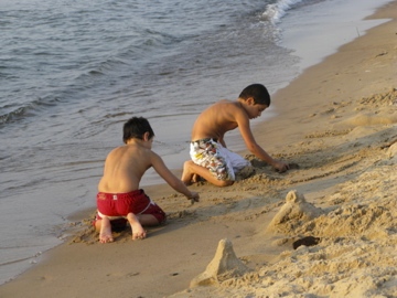 Boys making sand castles at the waterline of Lake Michigan