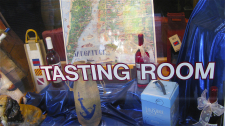 Wine tasting room window with bottles of wine and gifts in Saugatuck, Michigan
