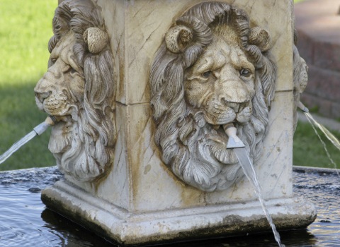 a fountain with lion heads and water spurting from their mouths