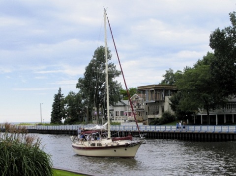 Sailboat with sails stowed heading up the Black River - South Haven, MI