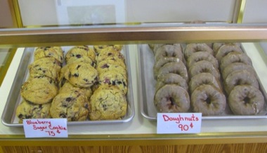 Freshly baked blueberry cookies and donuts for sale.