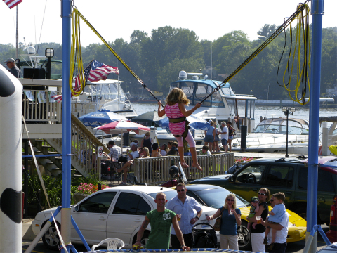 Kid jumping on a bungee over a trampoline in Saugatuck, Michigan