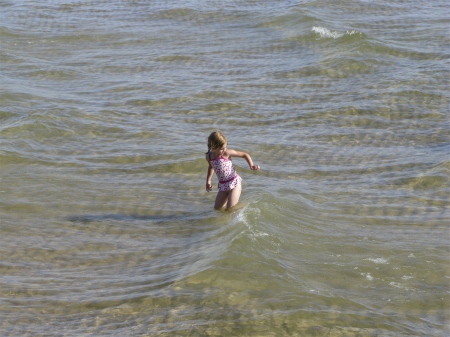Little girl wading in the waves