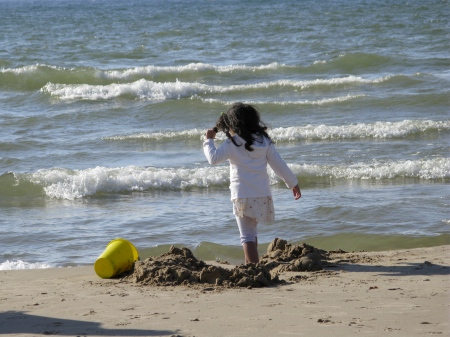 Girl playing in the sand at South Haven, Michigan