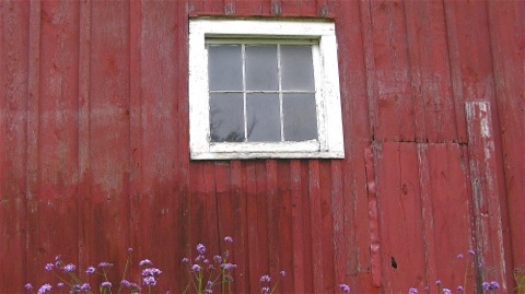 White window in a red barn wall