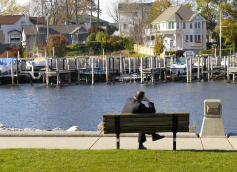 Man sitting on bench along the river in South Haven, Michigan